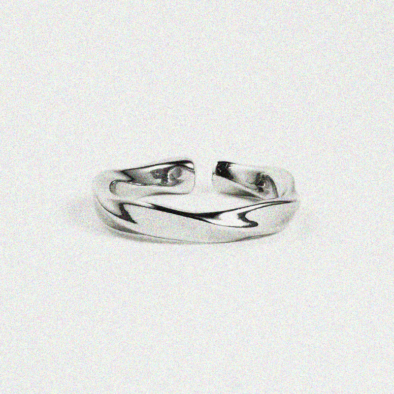  Silver band-style ring with a wavy design, displayed on a plain white surface.