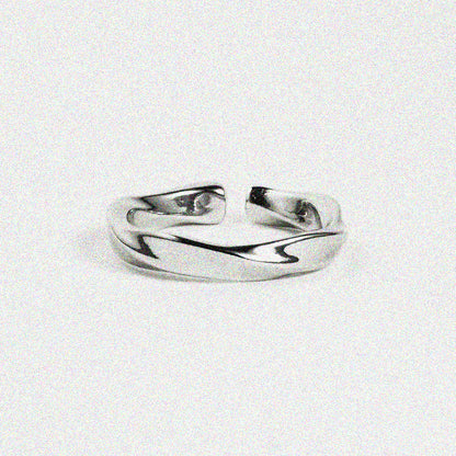  Silver band-style ring with a wavy design, displayed on a plain white surface.