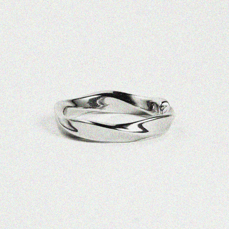 A smooth, twisted silver ring placed on a neutral background.