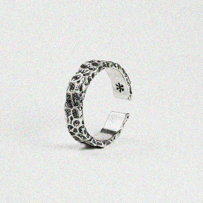 1. A silver ring featuring a delicate flower design, showcasing elegance and charm in its intricate details.

2. A beautifully crafted silver ring adorned with a floral pattern, perfect for adding a touch of nature-inspired style.

3. A stunning silver ring with a unique flower design, blending sophistication and natural beauty in one piece.

