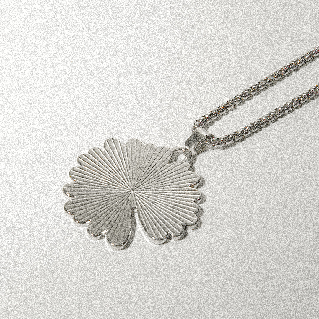 A silver necklace featuring a delicate leaf pendant, elegantly designed to enhance any outfit.
